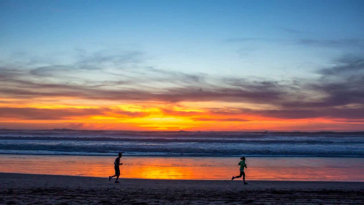 Joggers are silhouetted by a gorgeous sunset at Ocean Beach.
