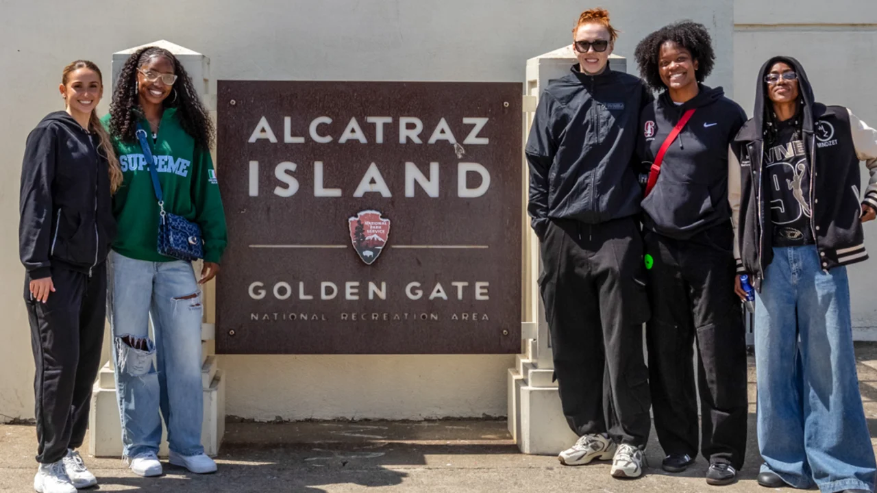 Five Golden State Valkyries players pose in front of the Alcatraz Island sign at the Golden Gate National Recreation Area.