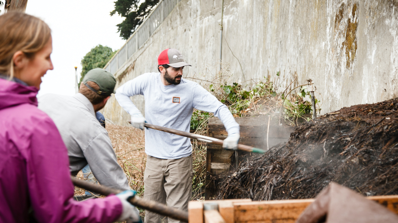 Parks Conservancy staff shoveling compost at the Alcatraz Historic Gardens