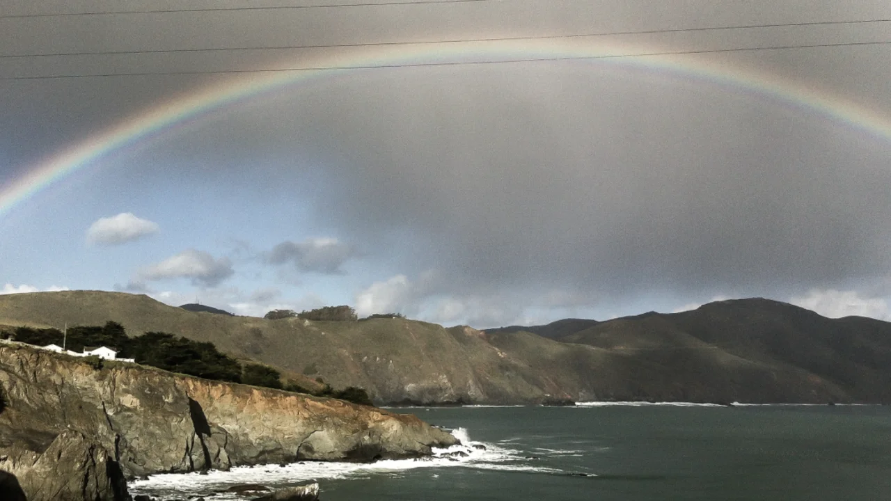 A rainbow shines over the headlands