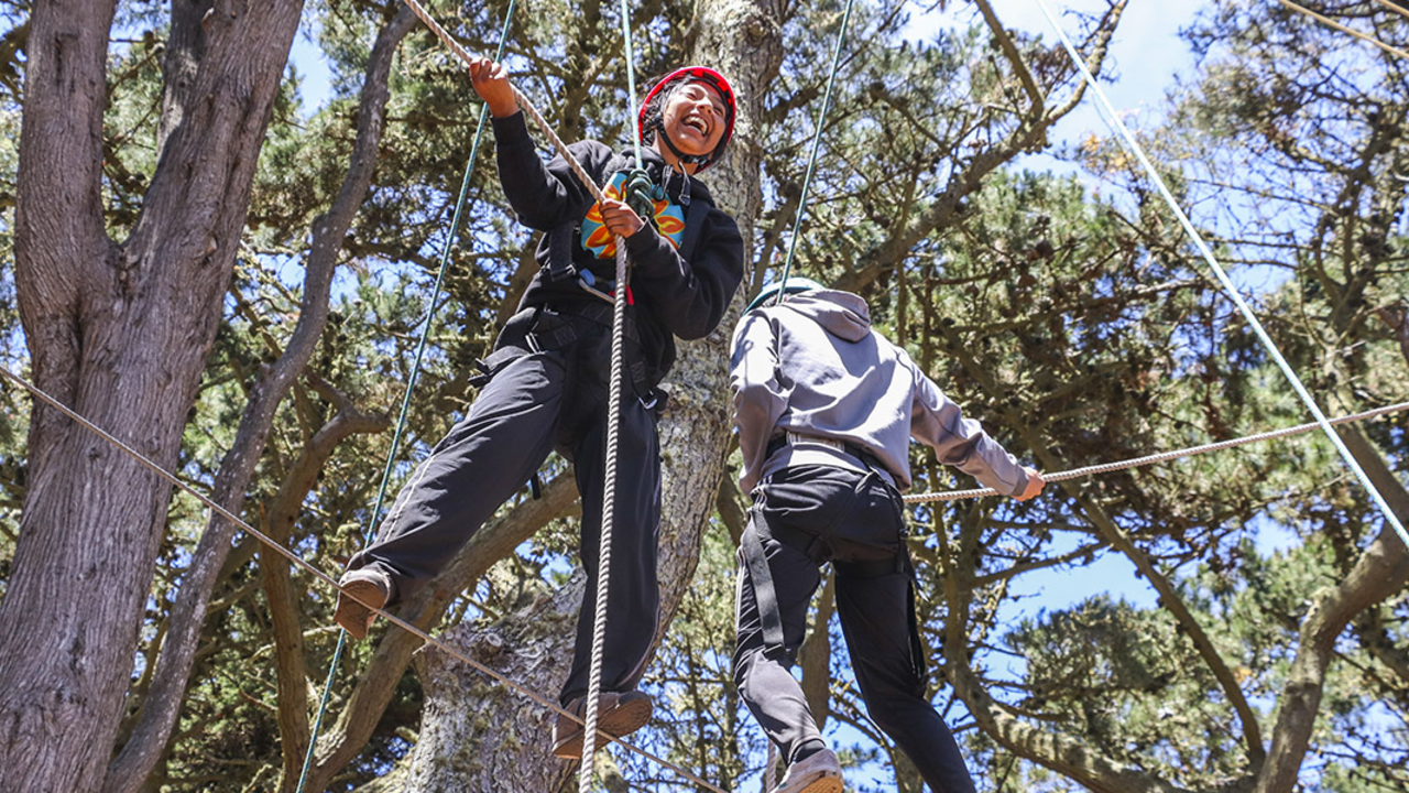Two youth at the top of a ropes course Two youth at the top of a ropes course