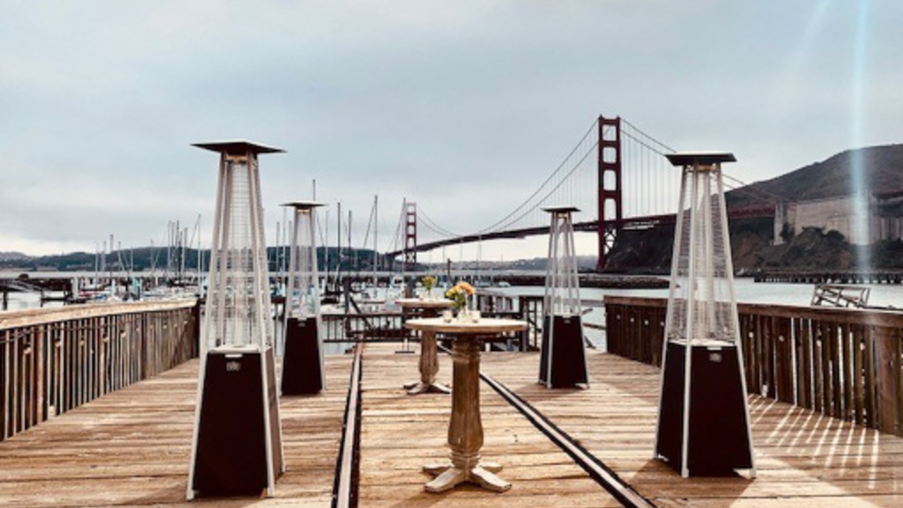 A dining table set on the waterfront of Fort Baker.
