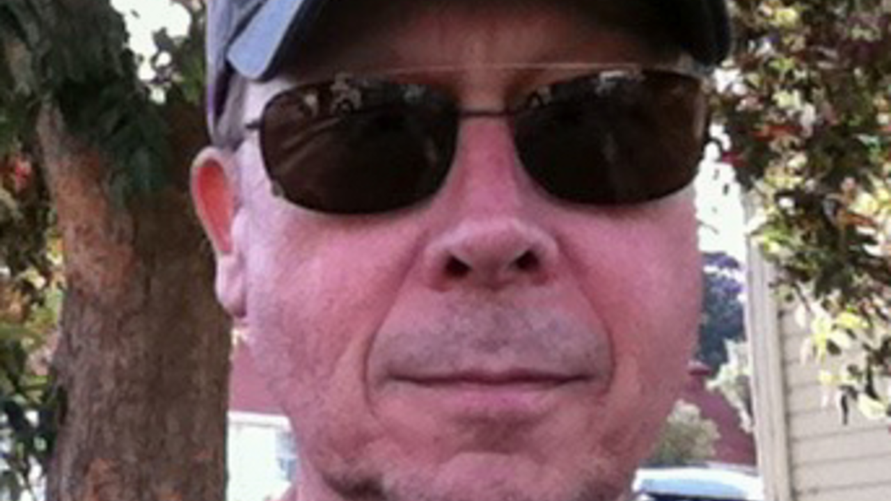 Portrait of a man wearing sunglasses and an NPS Volunteer hat.