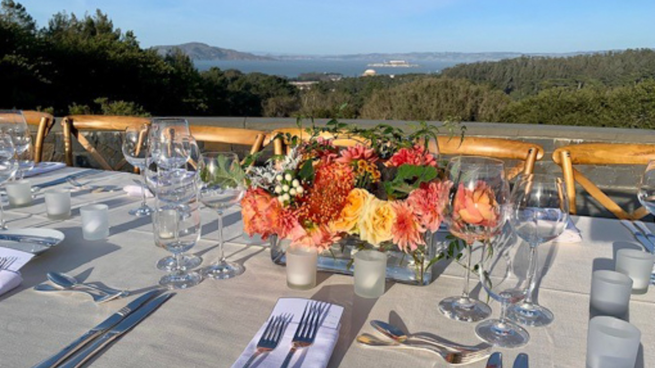 Dinning table set before a scenic San Francisco view at the Presidio.