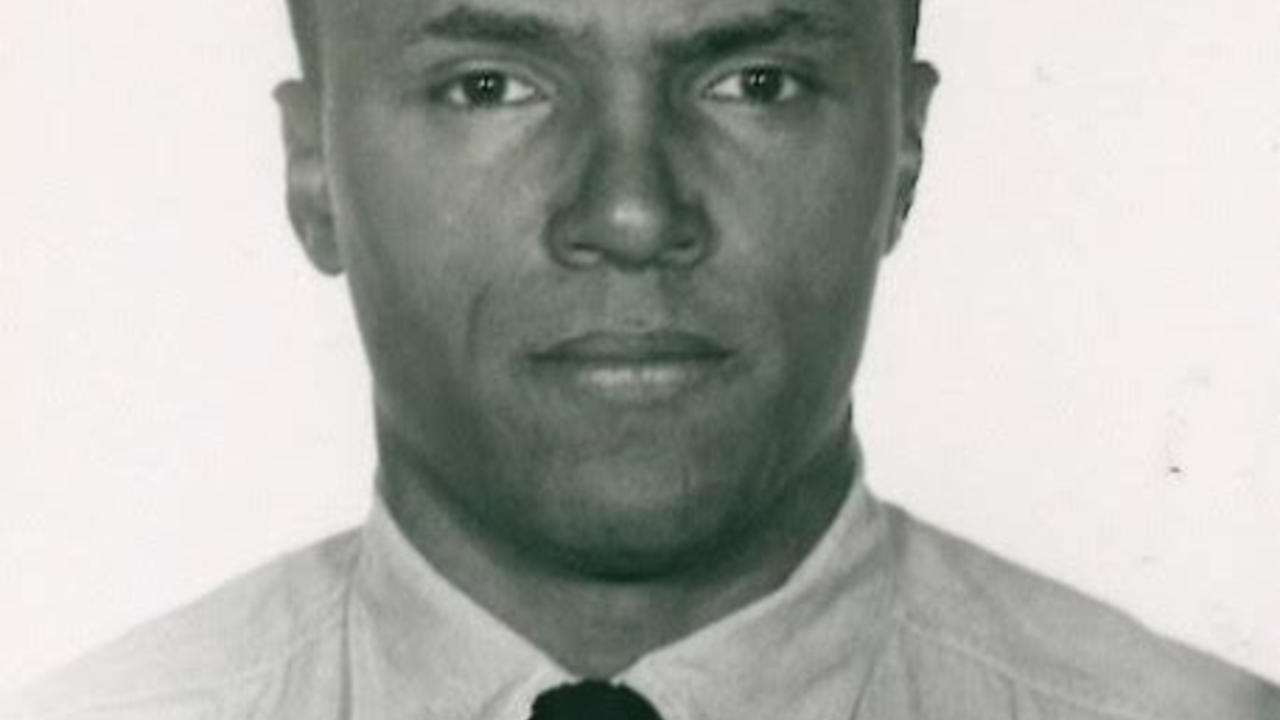 Robert Lipscomb, National Archives and Records Administration A black and white photograph of a Black man (Robert Lipscomb) in a white button-down shirt and a black tie. Presumably an intake photo for a federal prison.