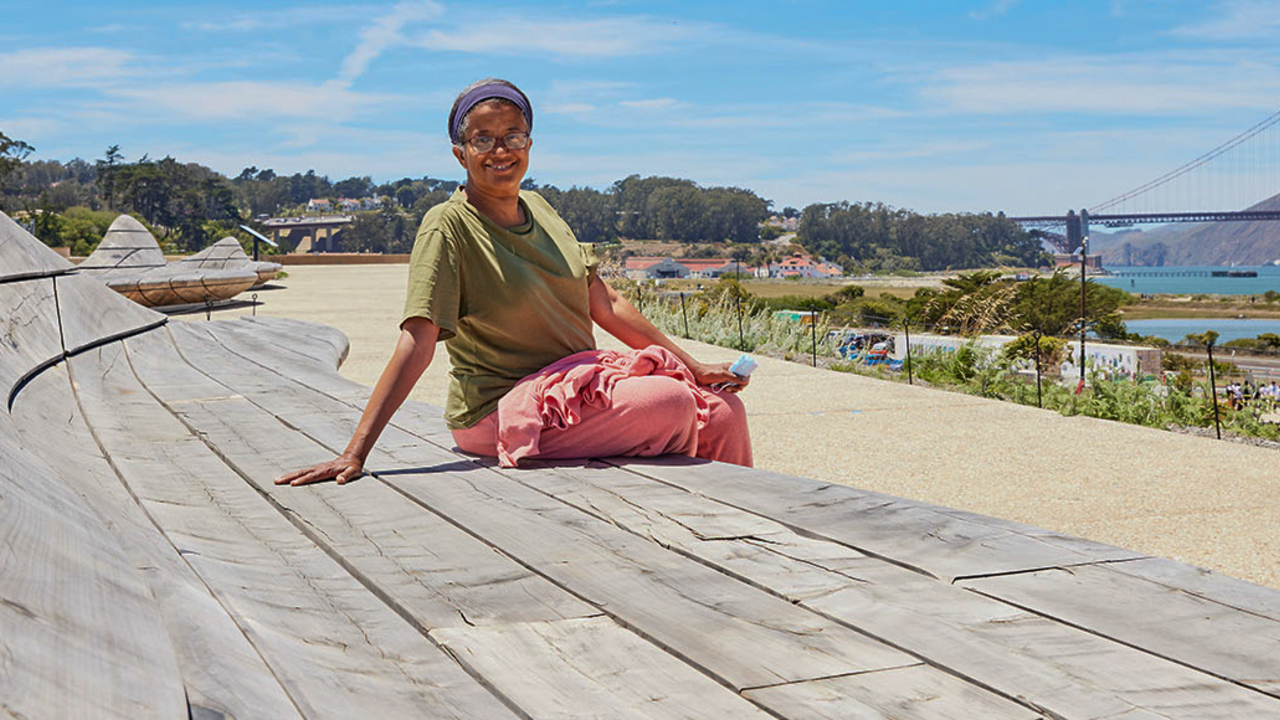 Person sits on cypress wood benches at Presidio Tunnel Tops.
