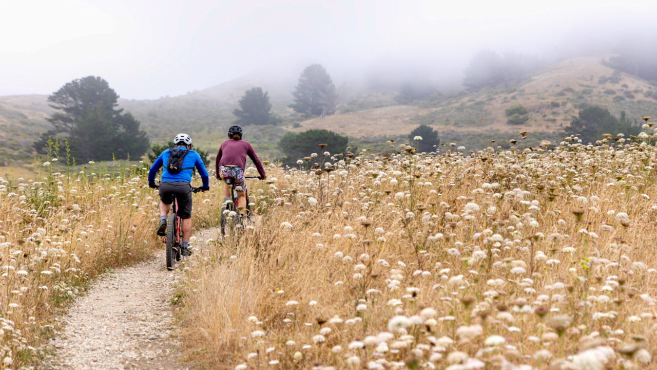 Two cyclists mountain biking a trail in Rancho Corral de Tierra