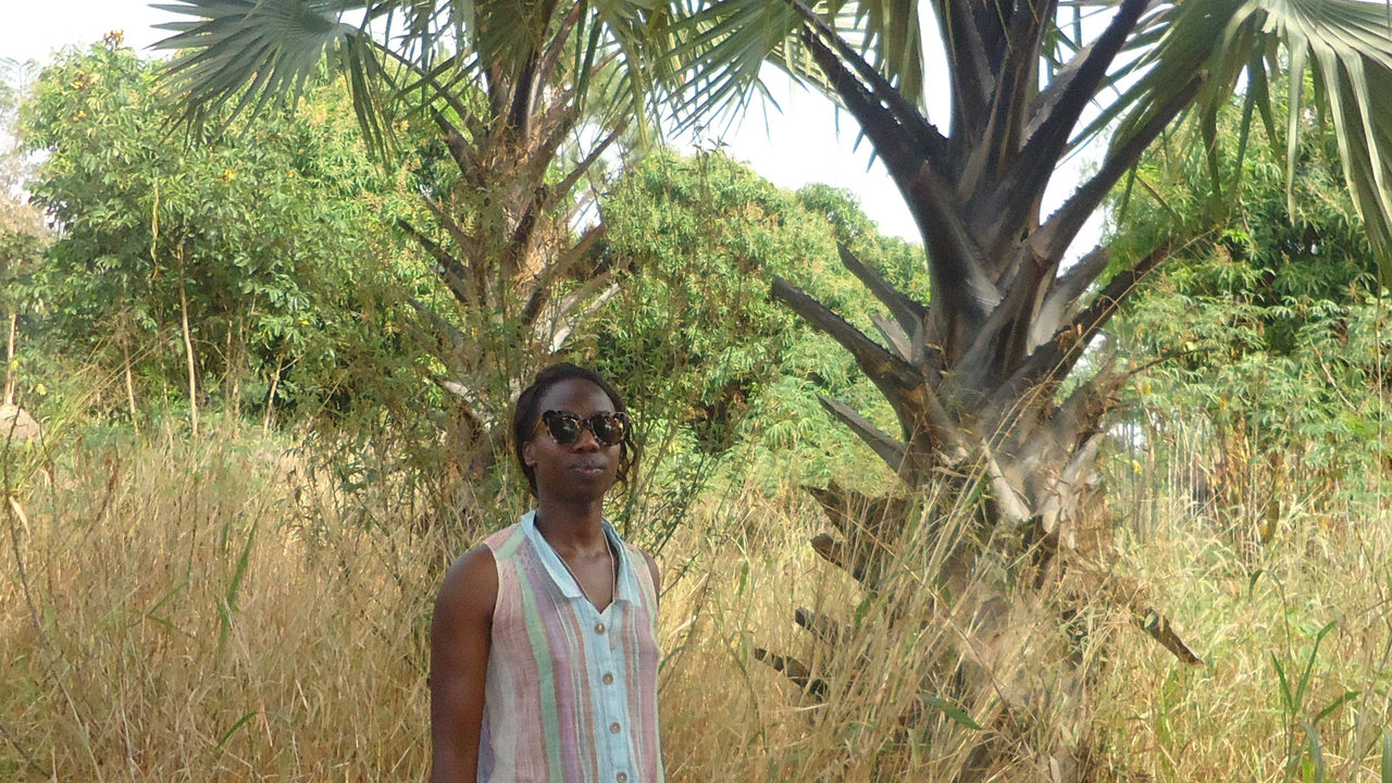 A woman stands in front of a tree in the southern hemisphere.