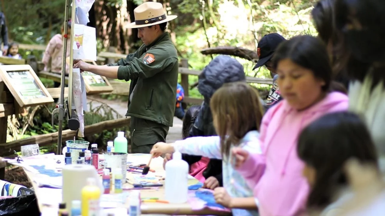 NPS Ranger hangs up watercolor art.