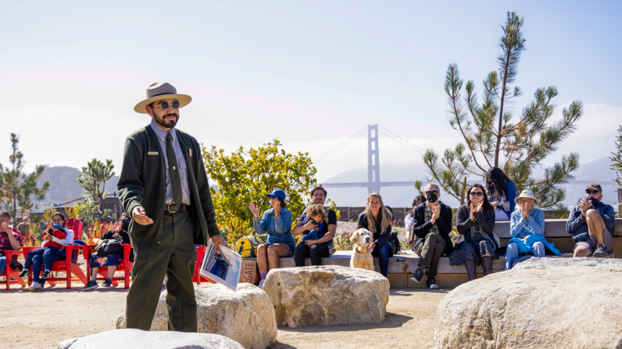 Ranger Talks at the Presidio Tunnel Tops Campfire Circle. An NPS park ranger speaks to a seated crowd around the Presidio Tunnel Tops Campfire Circle