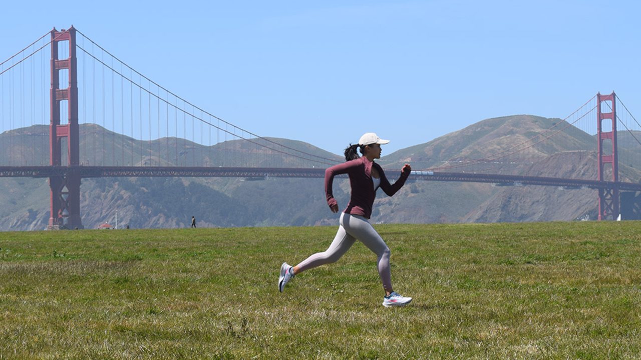 Laura Yin running at Crissy Field with the Golden Gate Bridge in the background.