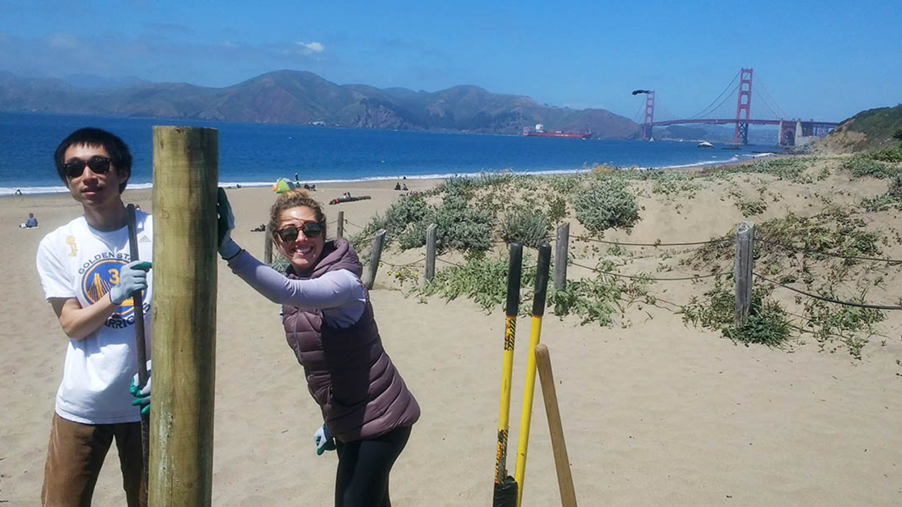Trail Crew volunteers help install fence posts at Baker Beach.