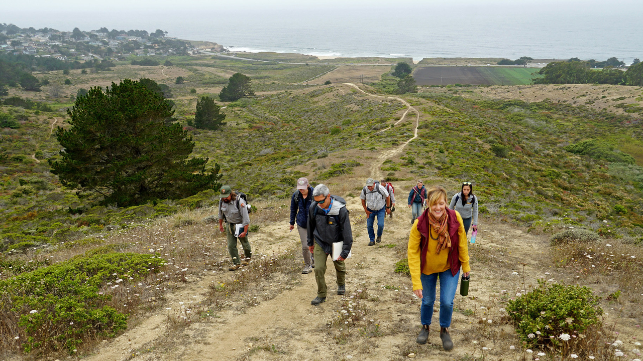 A group hikes up a path at Rancho Corral de Tierra. A group hikes up a path at Rancho Corral de Tierra.