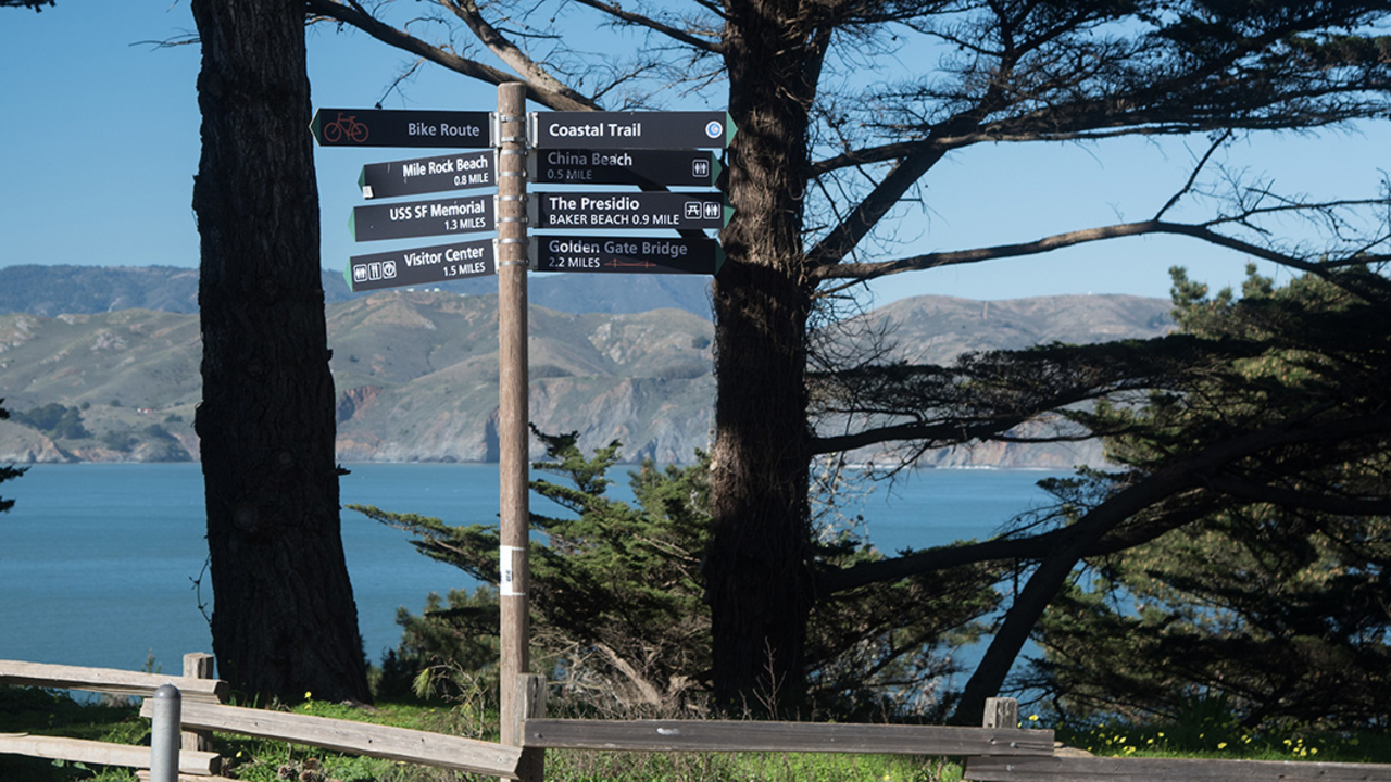california-coastal-trail-presidio-signage.jpg An image of multiple signs on a trial.