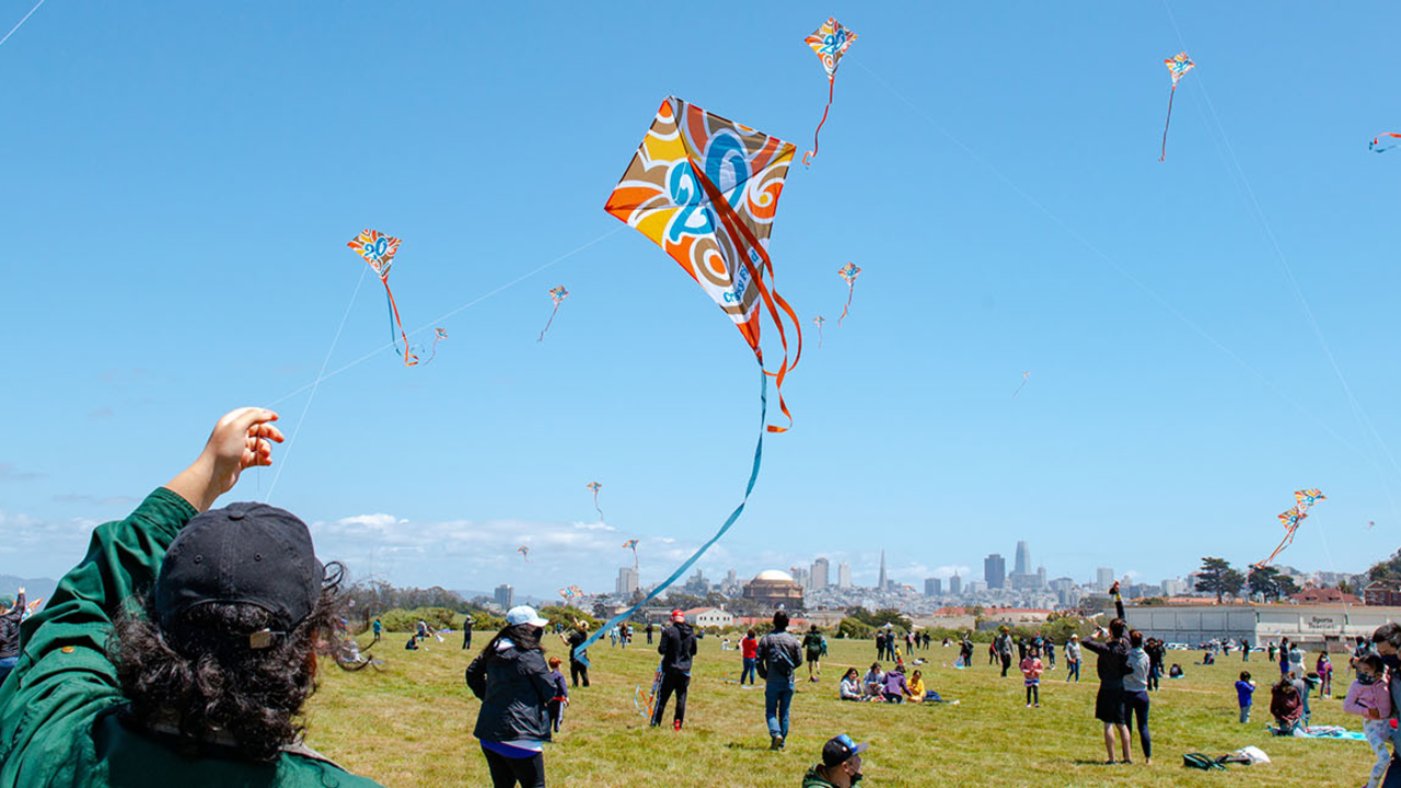 A park goer flies a Crissy Field 20th anniversary commemorative kite at the busy park.