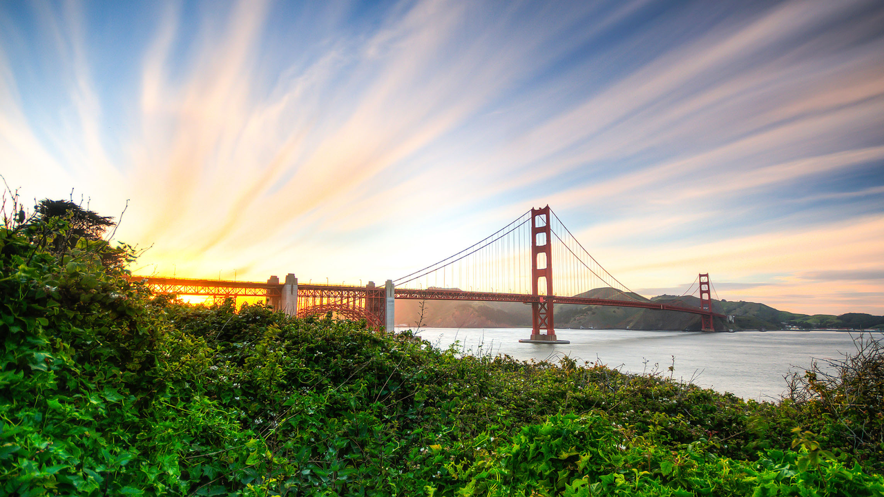 The Golden Gate Bridge seen with orange and yellow sunset in the background.
