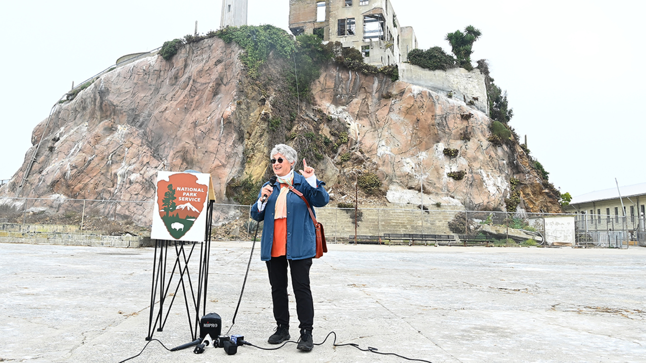 Jolene Babyak stands on the parade grounds on Alcatraz Island in front of reporters.