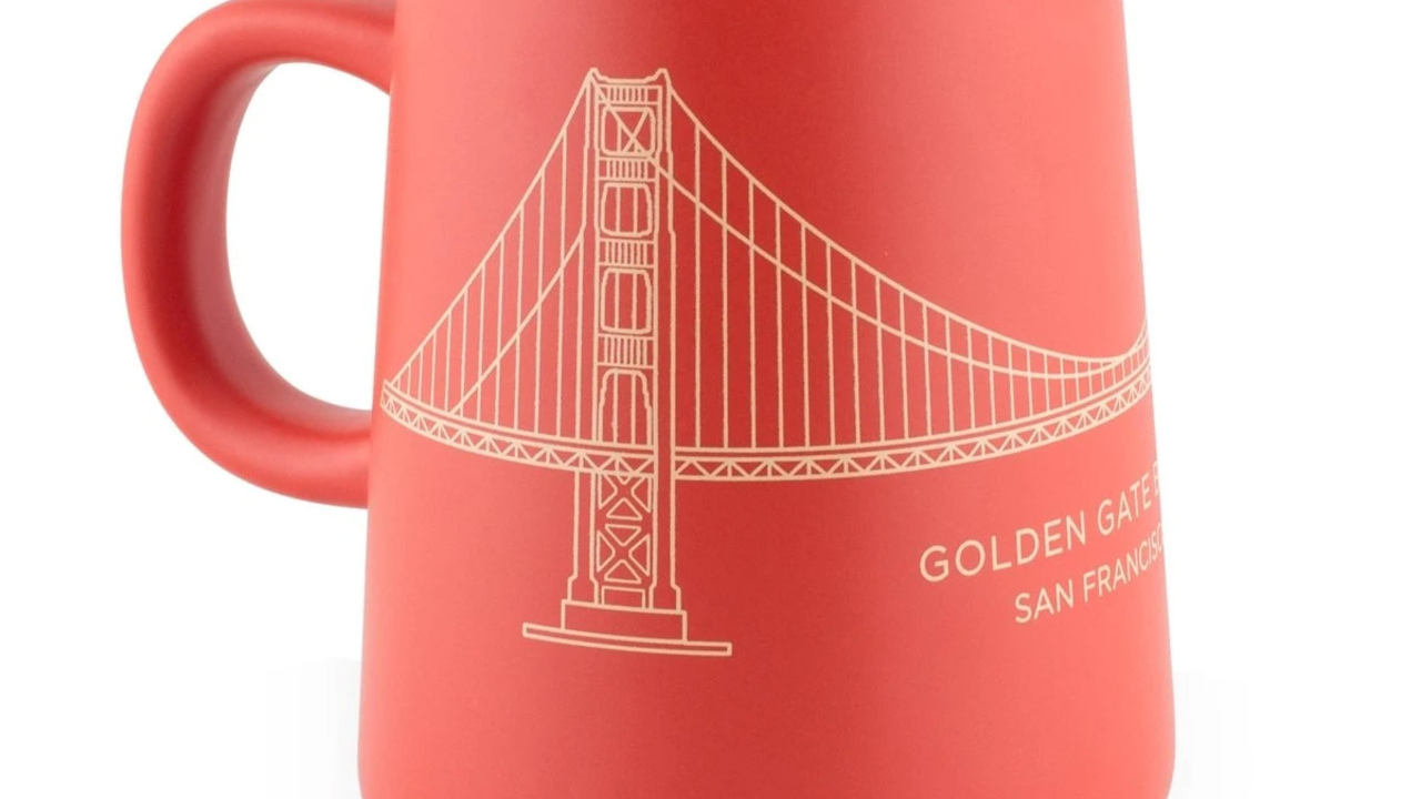 Red and gold tapered mug with a line drawing of the Golden Gate Bridge.