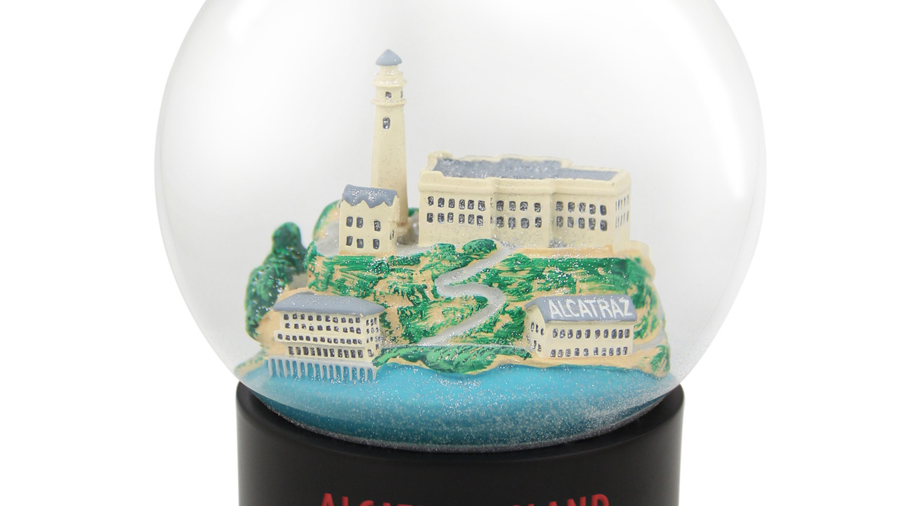 Model of Alcatraz inside a fog globe. The globe's base says "Alcatraz Island, San Francisco"