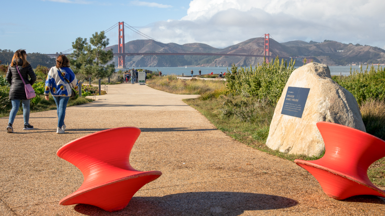 People walking a path in the Presidio Tunnel Tops with the Golden Gate Bridge viewed in the background.