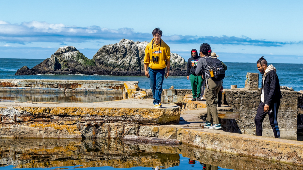 Park Hop day at Lands End 5 youth program participants walk amongst the sutro bath ruins at Lands End with an ocean backdrop on a sunny day