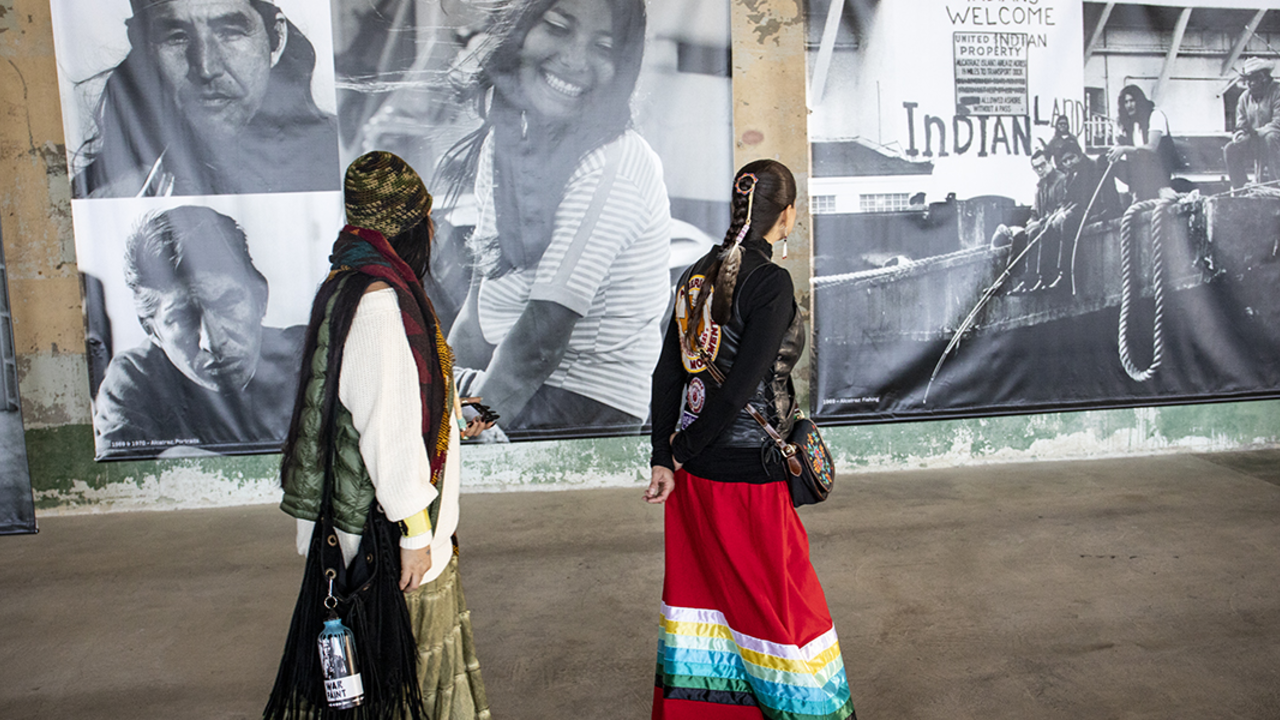 women walk past black and white photos