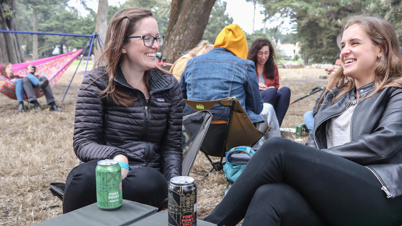 Two women sitting outside in the middle of a conversation.