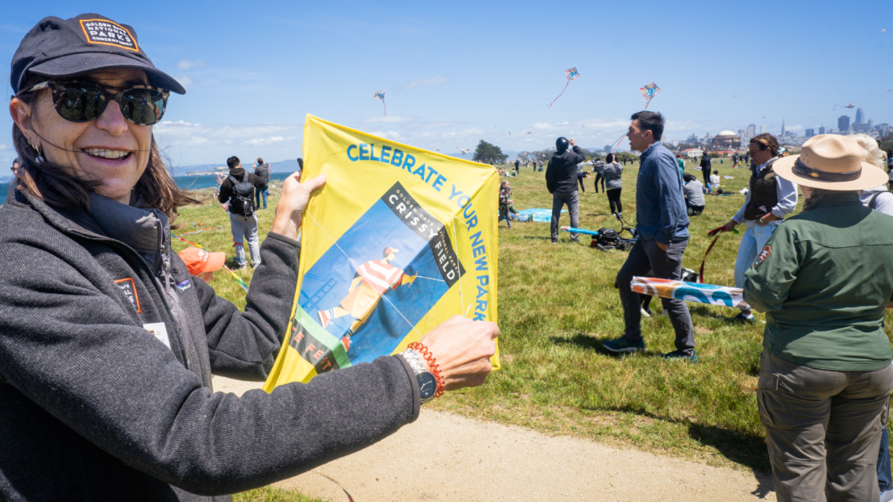 Parks Conservancy staff displays a commemorative kite from the opening of Crissy Field. Parks Conservancy staff displays the original commemorative kite from the opening of Crissy Field
