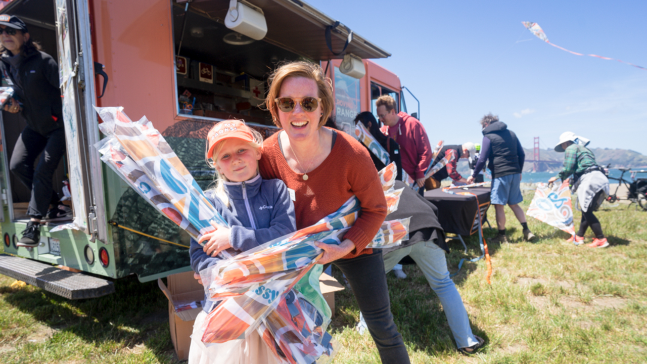 Conservancy staff and family help hand out kites at Crissy Field Kite Day