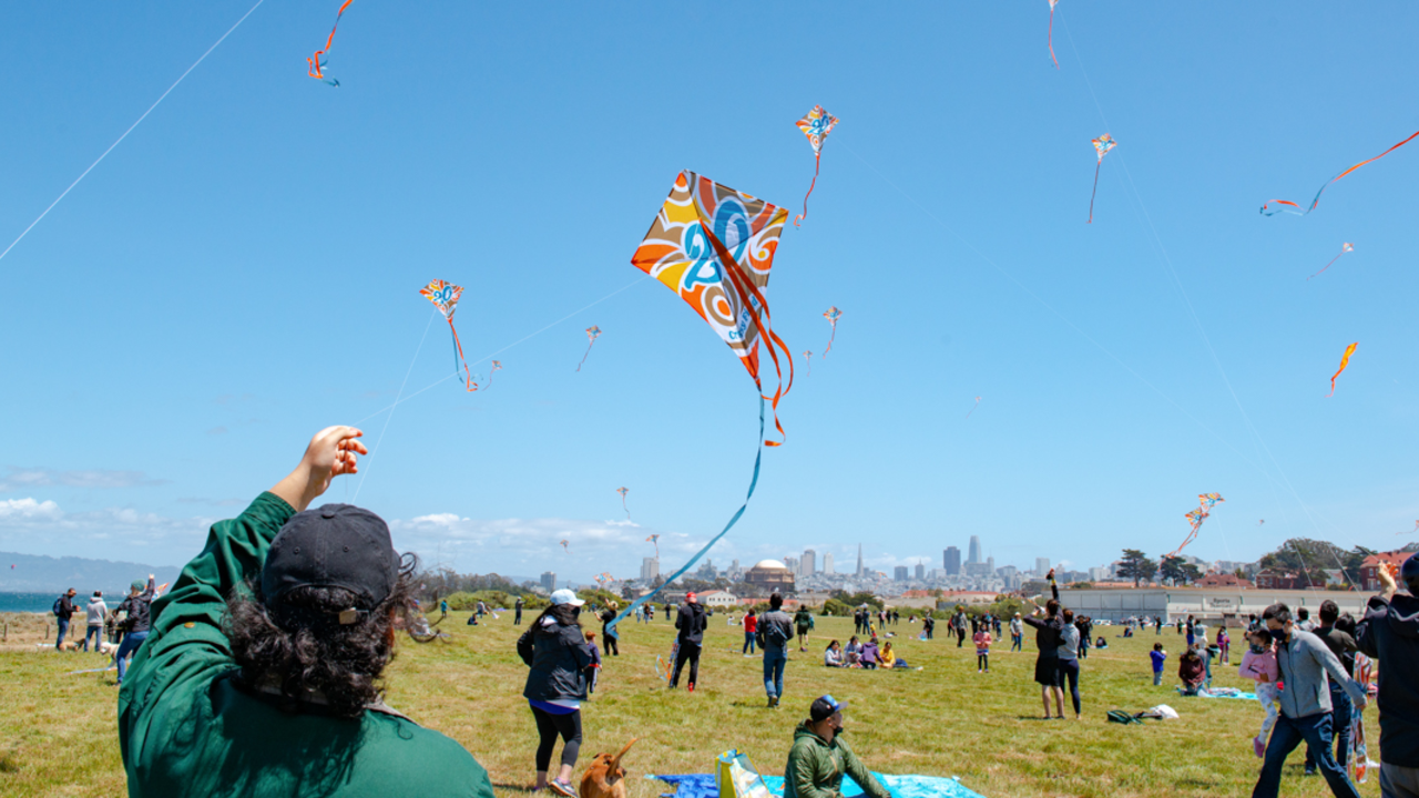 A park goer flies a Crissy Field 20th anniversary commemorative kite at the busy park.