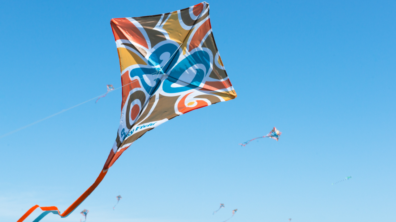 Crissy Field 20th anniversary kites flying through clear skies. Crissy Field 20th anniversary kites flying in the blue sky.