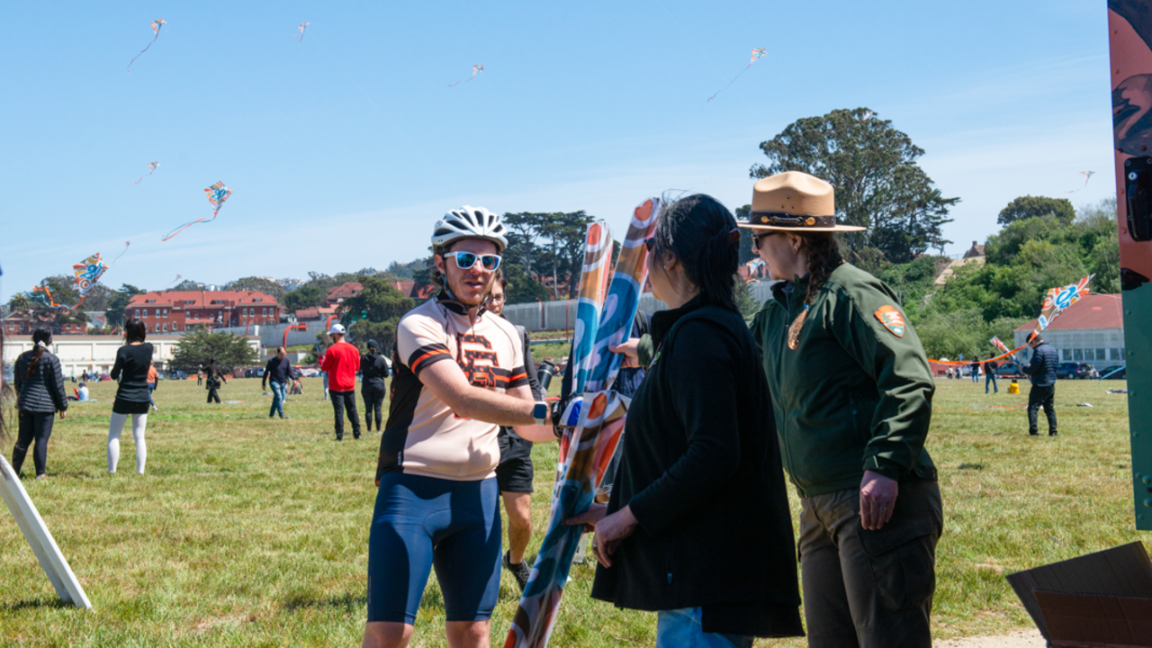 Park visitors received commemorative kites at Crissy Field Kite Day A park visitor receives commemorative Crissy Field 20th anniversary kites from staff at the Roving Ranger.