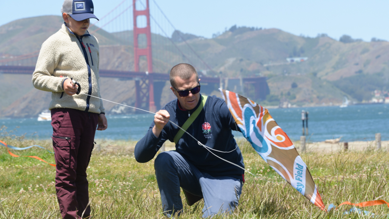 Kite Maintenance at Crissy Field. A parent helps their child with a kite at Crissy Field.