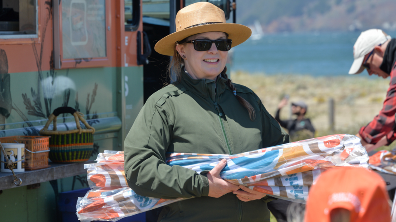 NPS Ranger Distributes Kites. NPS ranger holding kites to distribute at the Crissy Field Kite Day event