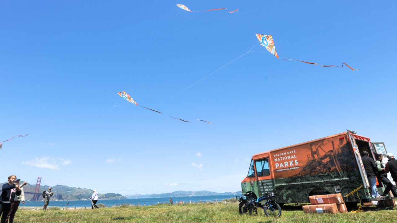 Children fly kites nearby the Roving Ranger at Crissy Field.