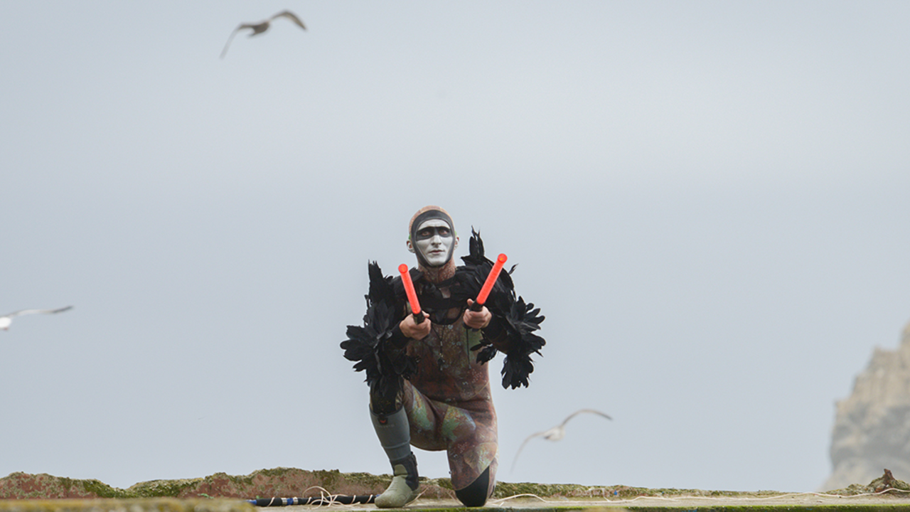 LAEN_20191019_RCW_34_2x1.jpg Musician Andy Meyerson wears an elaborate costume on ruins of Sutro Baths with birds flying in background.
