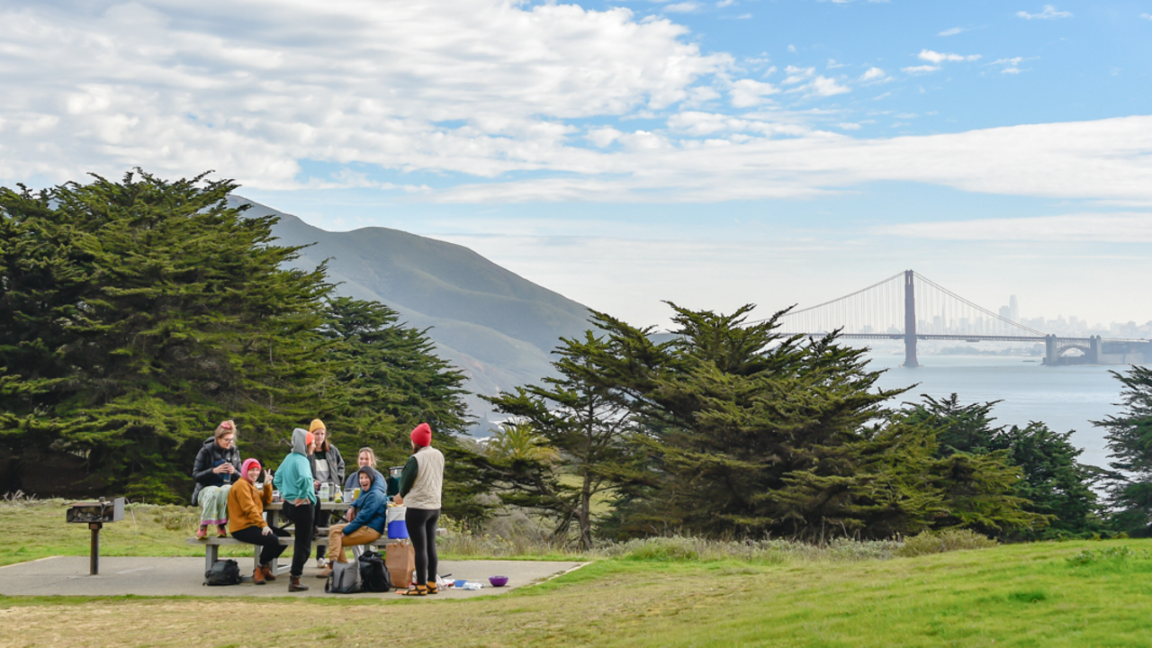 People sit at a park picnic table in the Marin Headlands