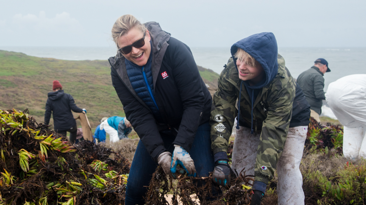 Volunteers remove invasive species of plants during MLK Day of Service Volunteers smiling while removing ice plant in the Marin Headlands