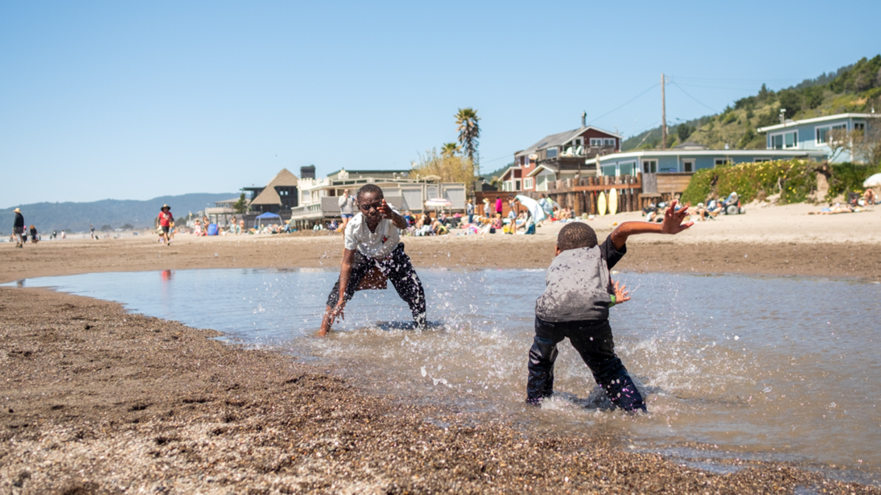 Fun in the sun at Stinson Beach Two kids at play, splashing in the water on a sunny day at Stinson Beach