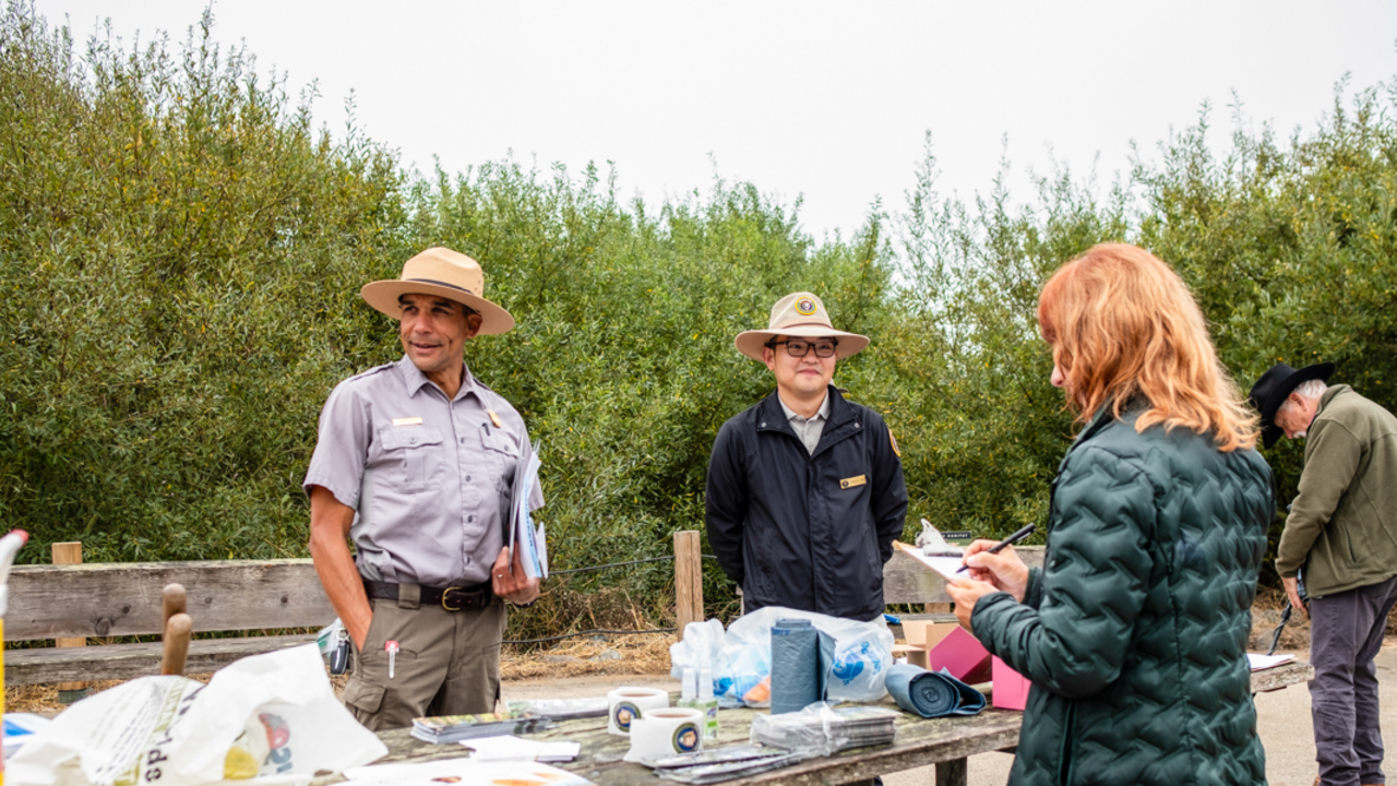 NPS rangers check in volunteers at Coastal Cleanup Day 2024 in Muir Beach