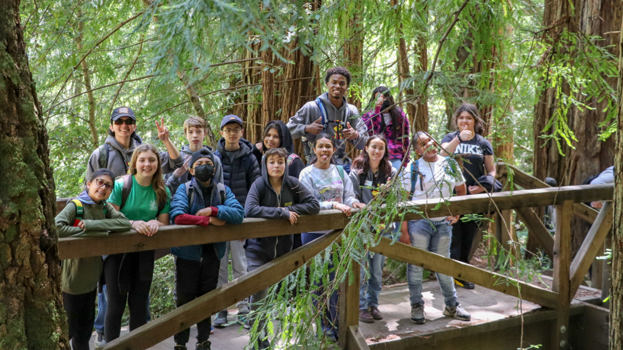 A group of Crissy Field Center Urban Trailblazers pose for a photo on a bridge in Muir Woods