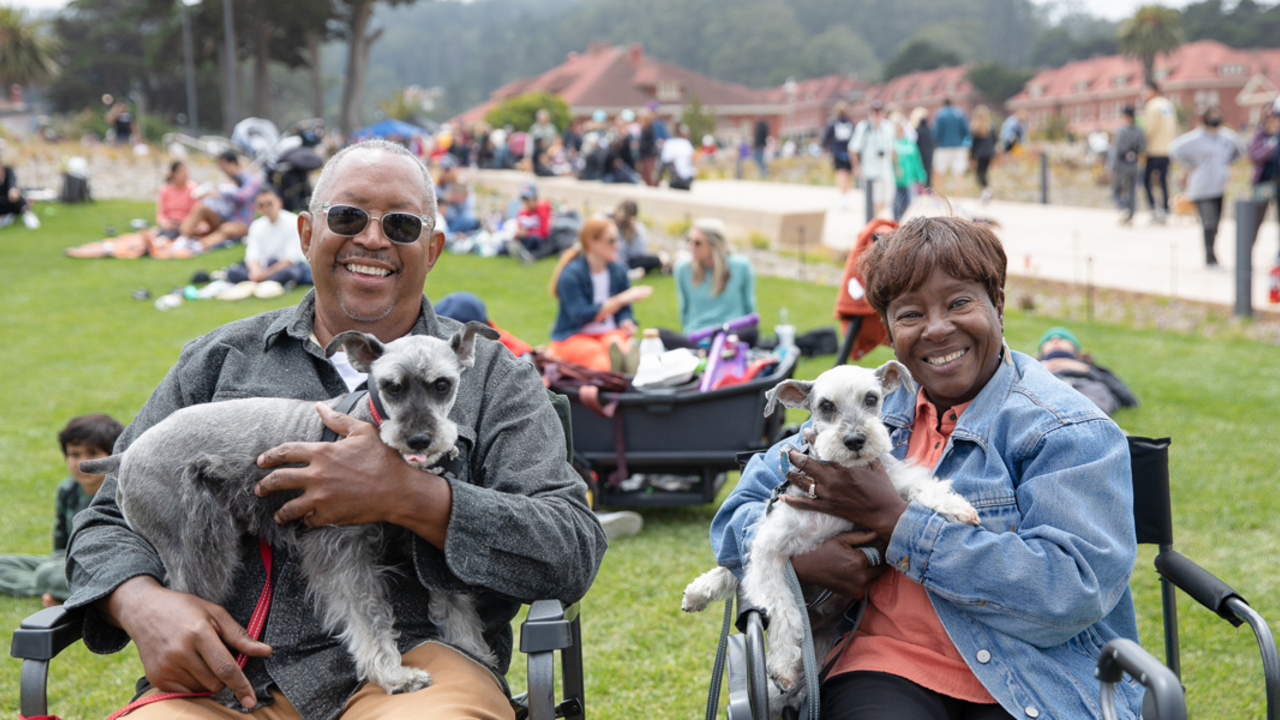 A couple relaxing at Presidio Tunnel Tops with their two dogs. A couple relaxing at Presidio Tunnel Tops with their two dogs.