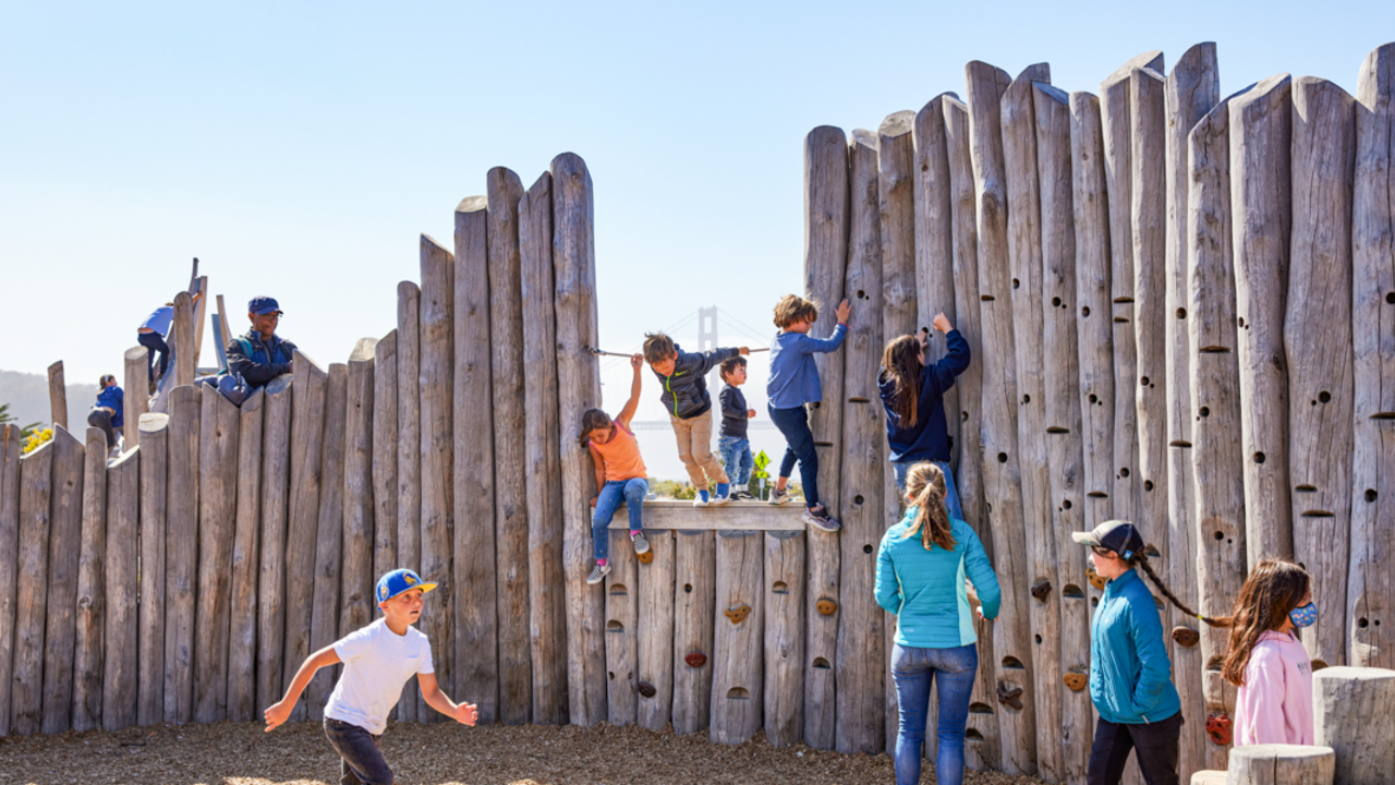 Kids at play at The Outpost. Kids at play on the climbing wall of The Outpost at Presidio Tunnel Tops.