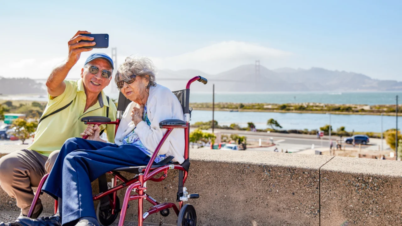 Elderly couple poses for a selfie before the Golden Gate Bridge at Presidio Tunnel Tops.