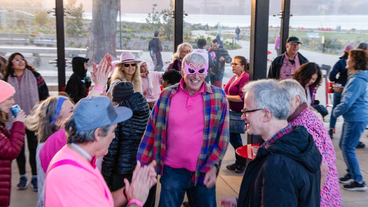 People dressed in pink joyfully dancing and celebrating at the Pink Full Moon party in the San Francisco Presidio