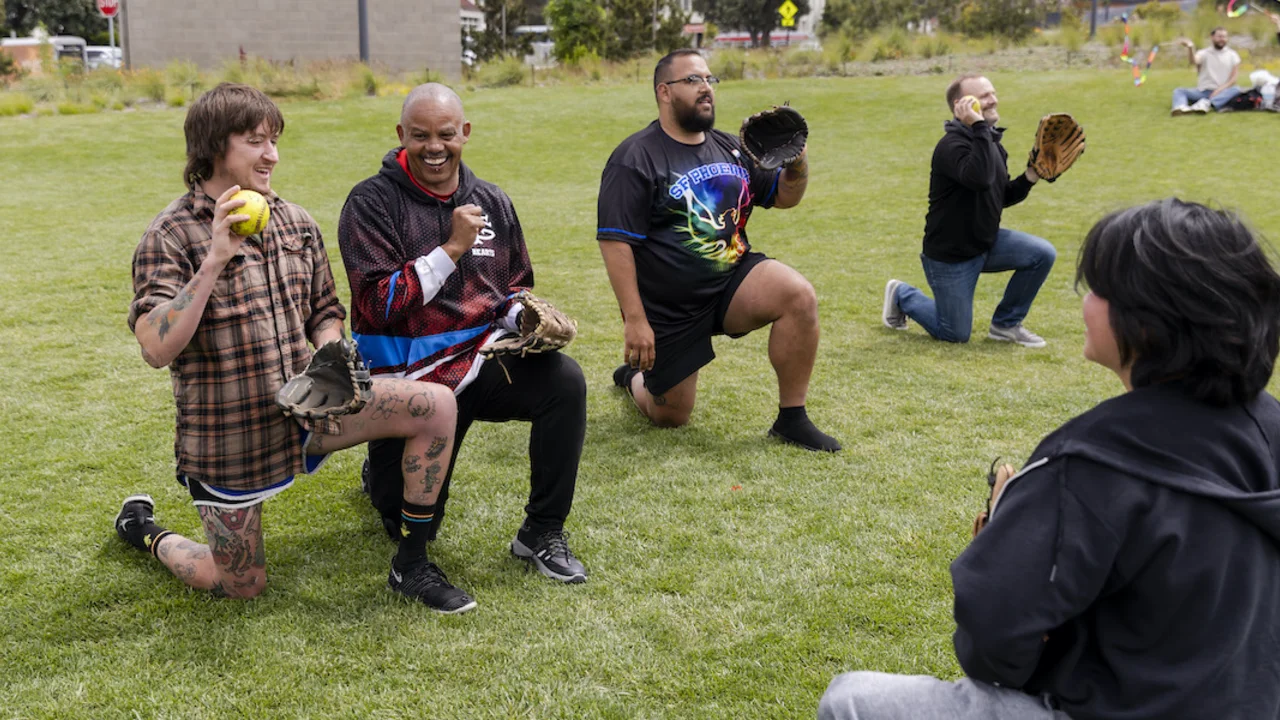 People crouching to play catch at Fantastic Field Day on June 11, 2023.