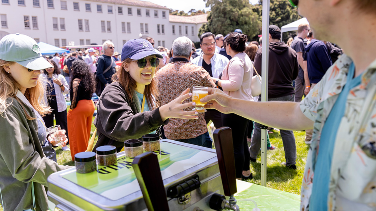 Buck Wild Brewing hands event attendee a tasting glass full of beer at Parks4All: Brewfest, a beer festival and fundraiser, on Saturday, July 29th, 2023 in the Presidio of San Francisco.