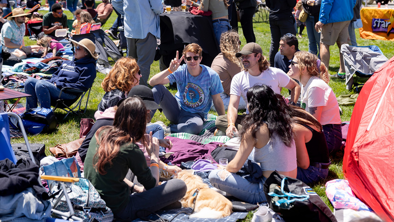A group of friends sitting on a picnic blanket at Parks4All: Brewfest, a beer festival and fundraiser, on Saturday, July 29th, 2023 in the Presidio of San Francisco.