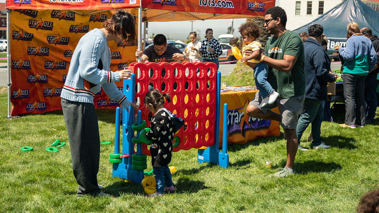 A kid plays Connect Four at Parks4All: Brewfest, a beer festival and fundraiser, on Saturday, July 29th, 2023 in the Presidio of San Francisco.