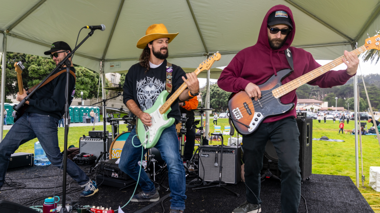 A band energetically performing on a stage in the Presidio during Parks4All: Brewfest 2024